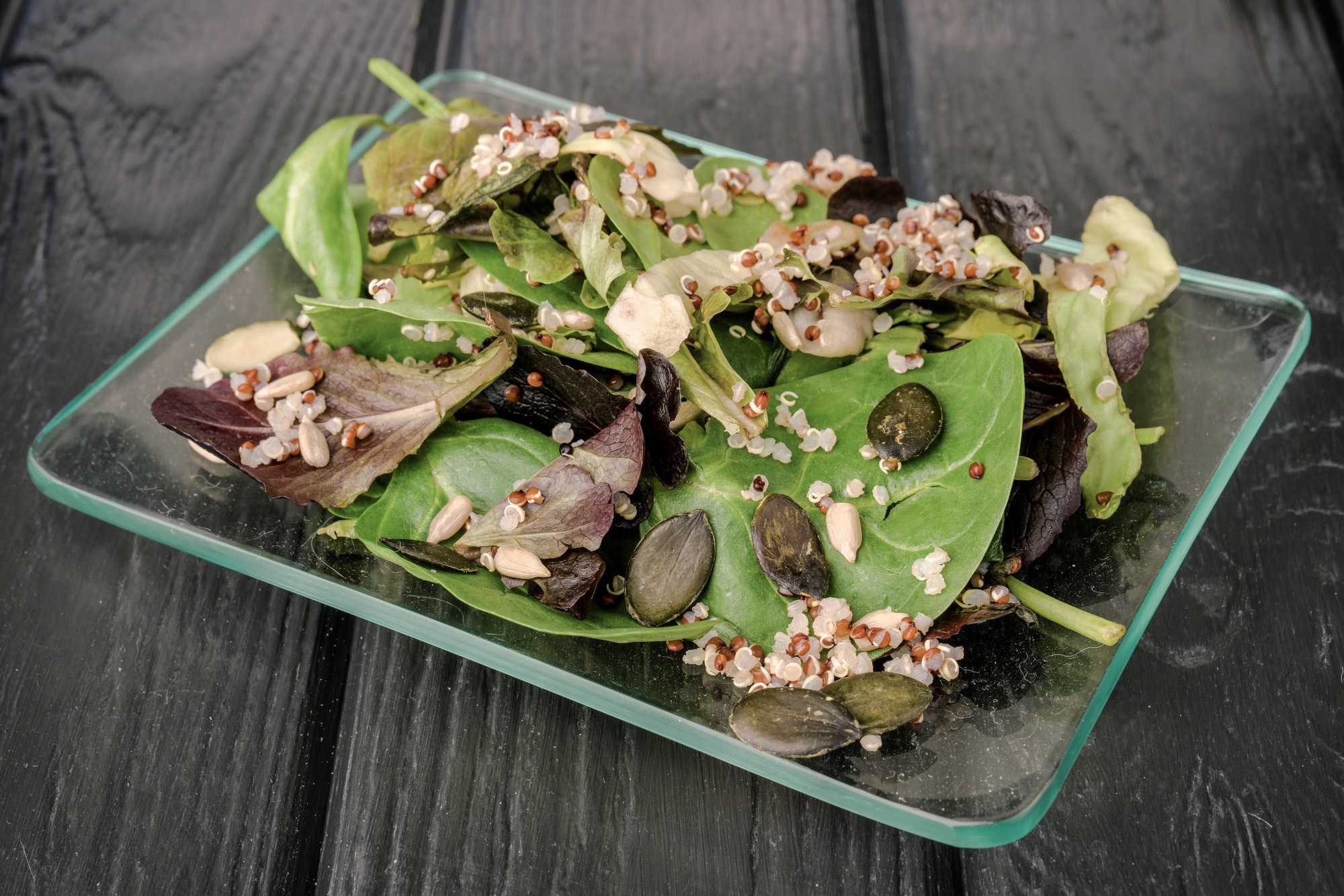 Quinoa seed salad in glass bowl on black board